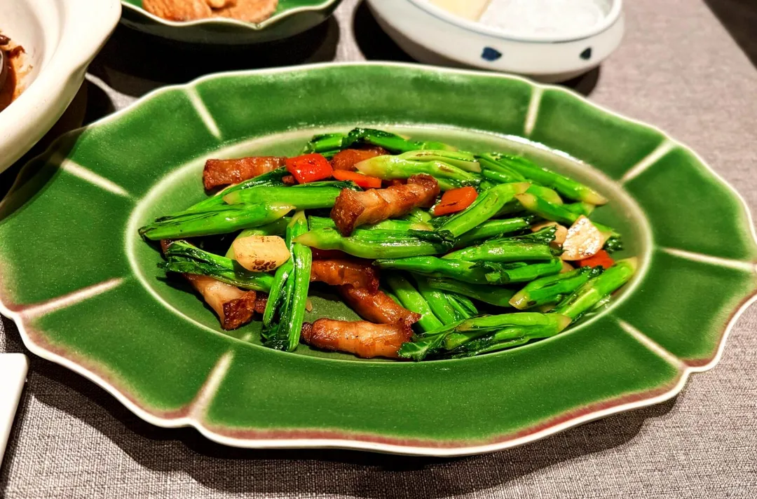 Green ceramic platter with vegetables and sliced meat at Alila Shanghai