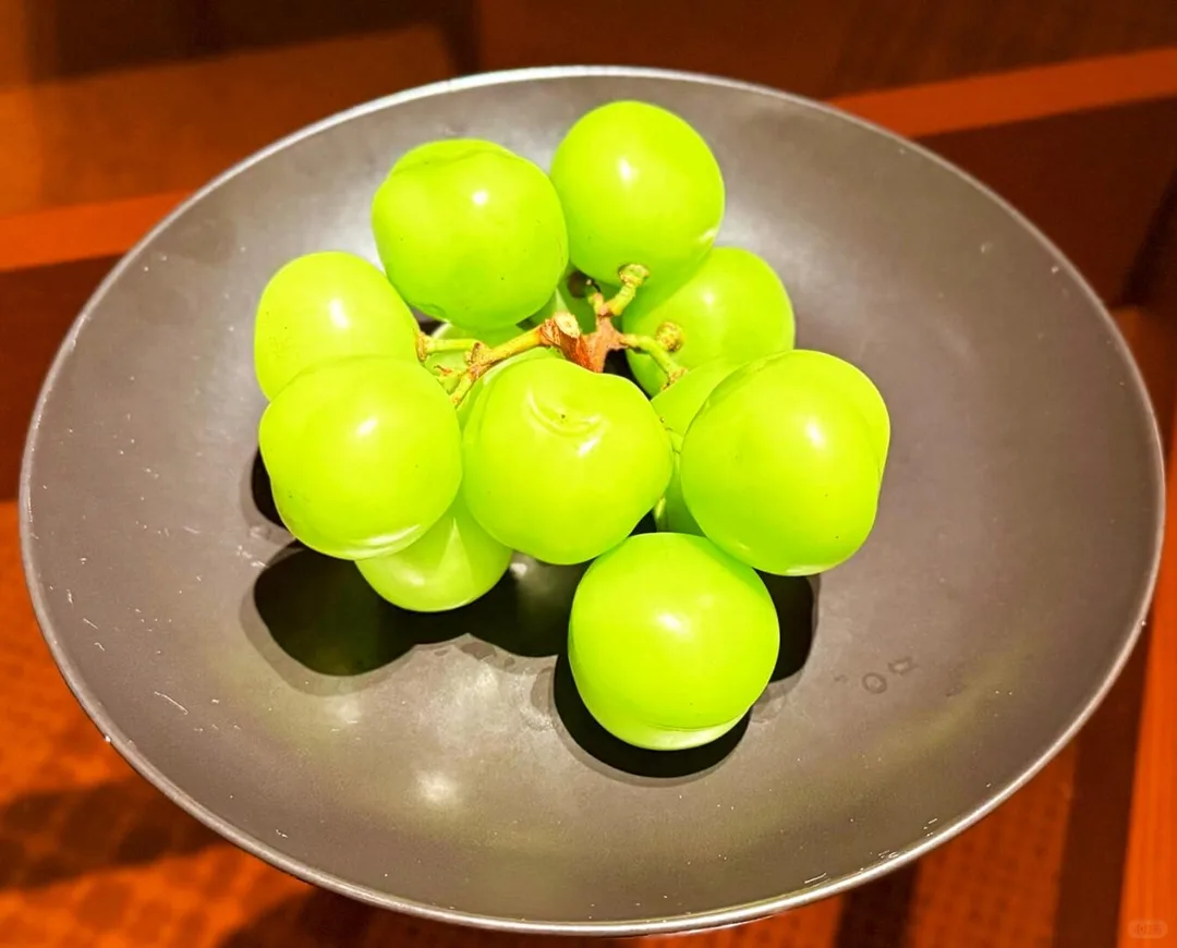 Bright green welcome grapes presented in a dark ceramic bowl at Alila Shanghai