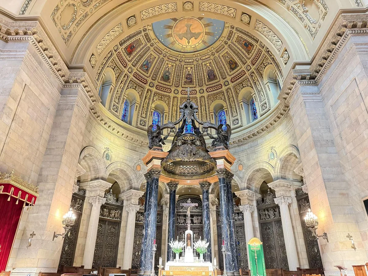 Cathedral high altar beneath a black marble baldachin and decorated sanctuary dome
