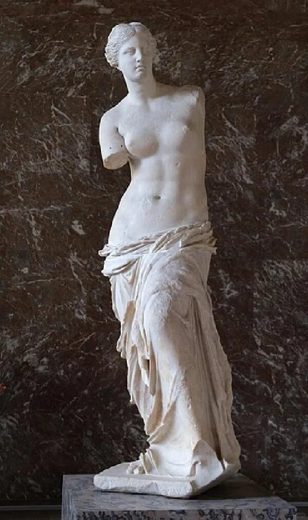 Venus de Milo displayed against dark stone at the Louvre