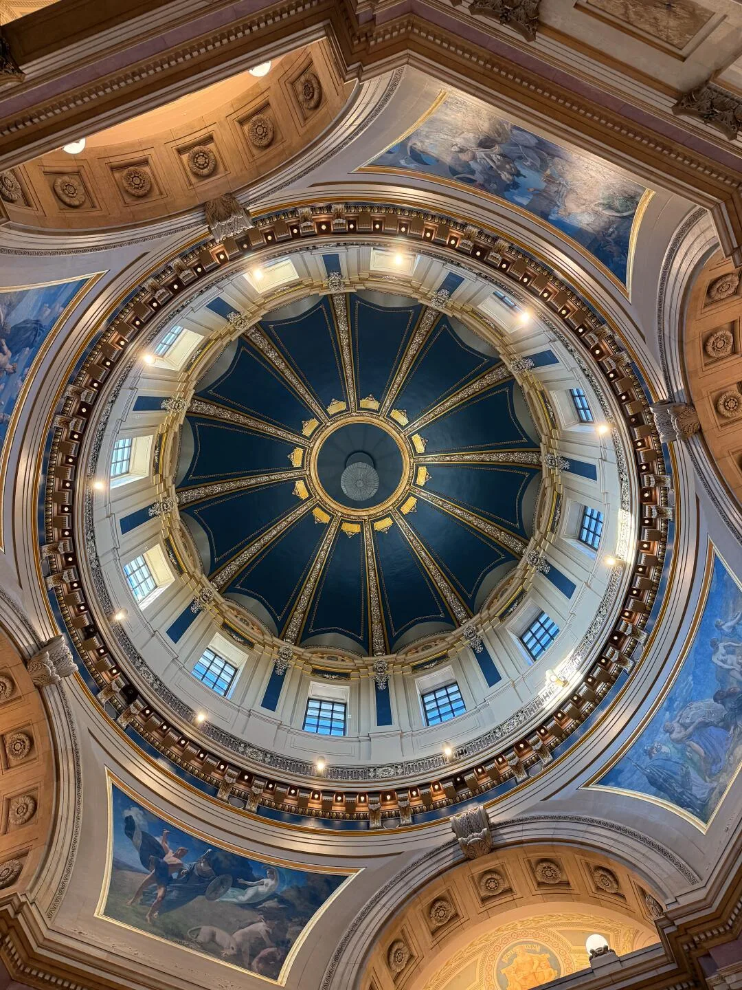 Painted panels and blue-green windows around the Minnesota Capitol rotunda dome
