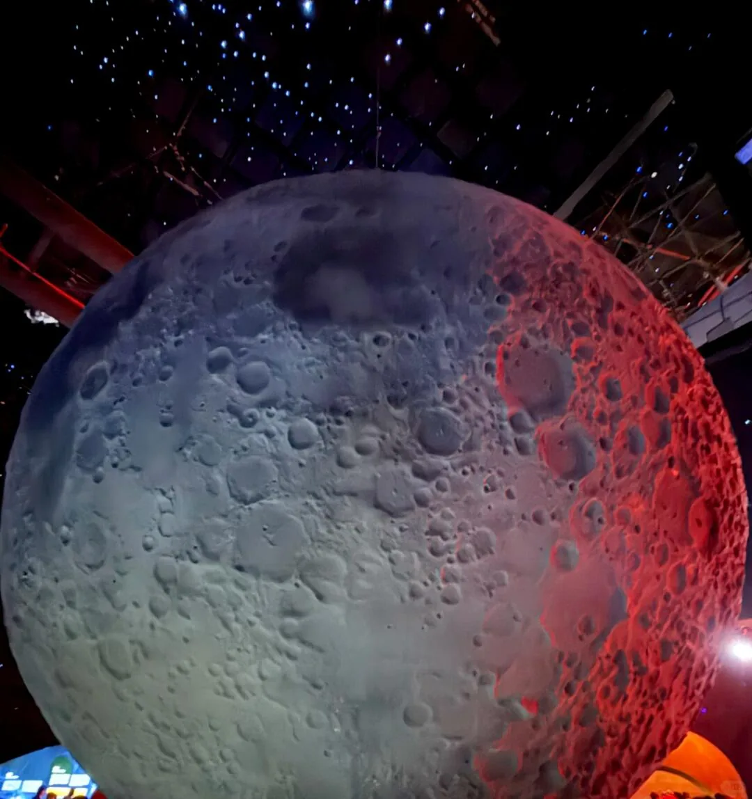 Large illuminated Moon model beneath a starry ceiling at Shanghai Astronomy Museum