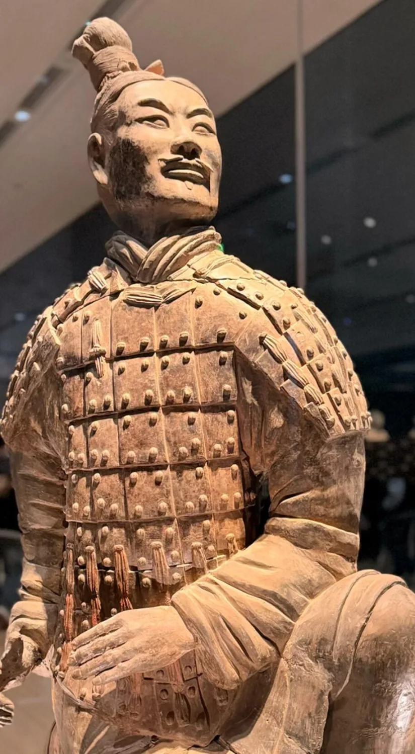 Close view of a kneeling terracotta archer showing detailed armor and hairstyle